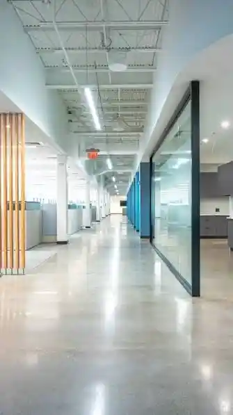 Modern office interior with glass partitions and polished flooring showcasing commercial interior construction services.